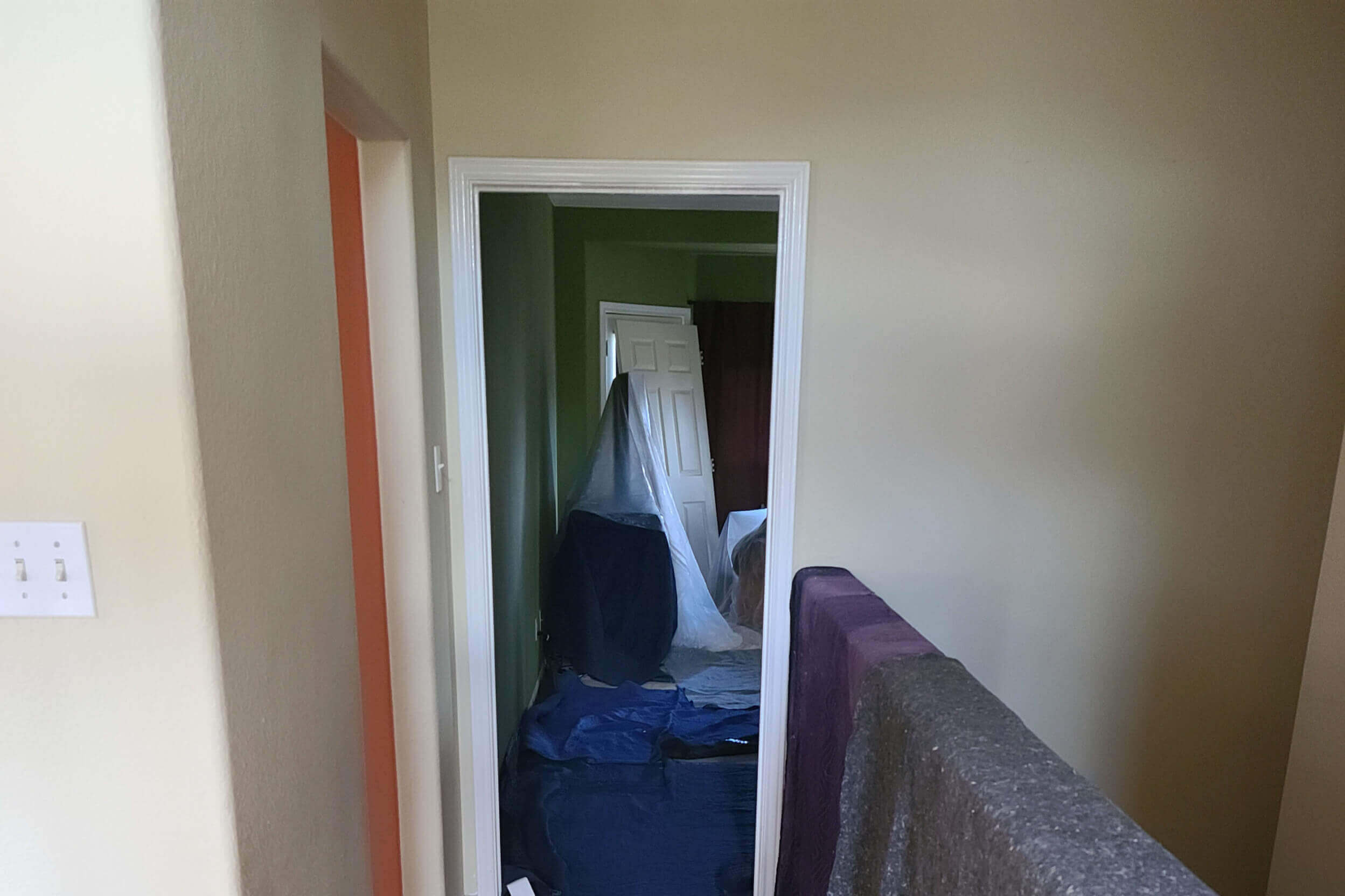 Inside of a home being remodeled with protective sheets put down on the floor and on the stair railing