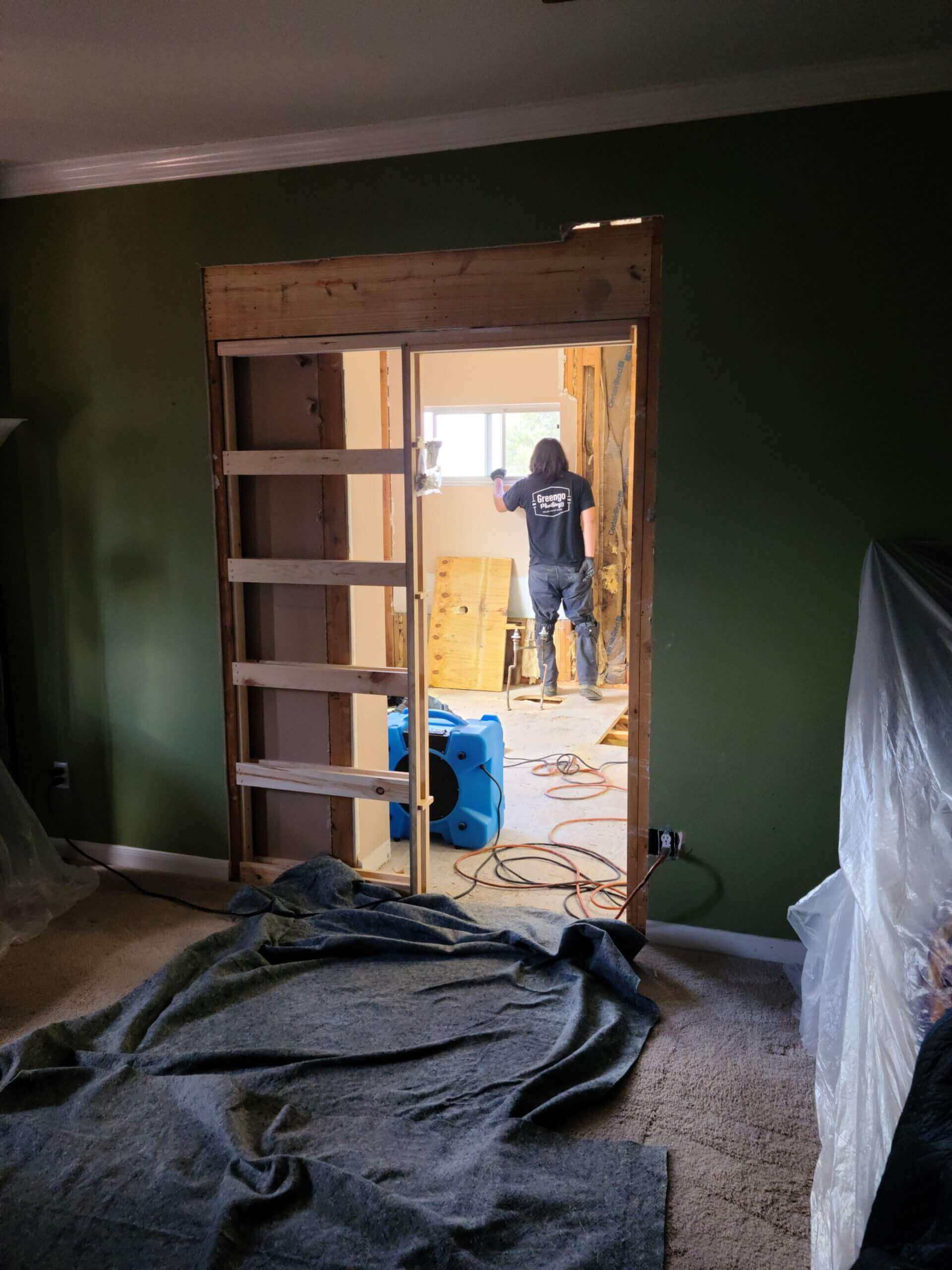 An air scrubber and safety coverings on the floor of a house being remodeled