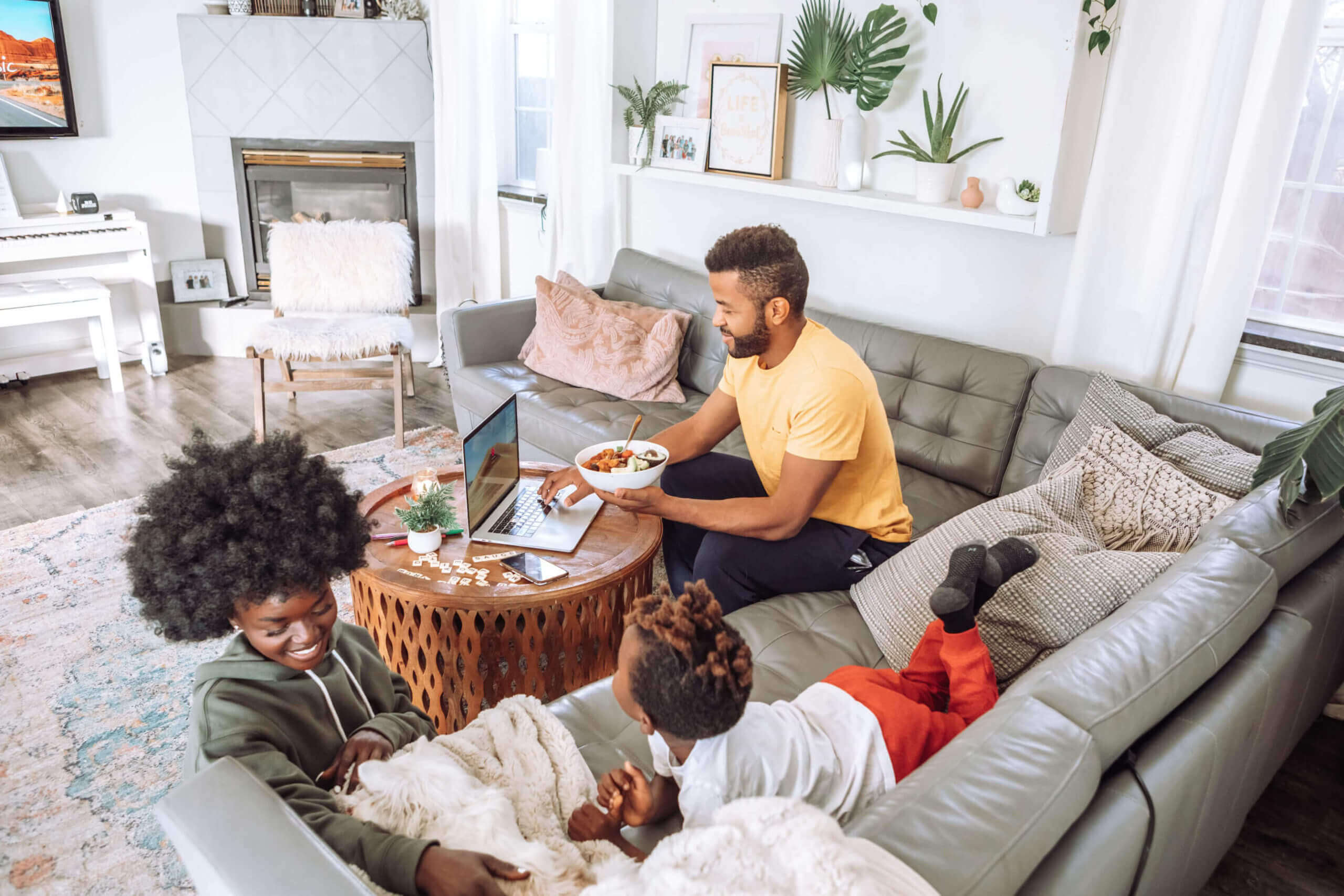 Family room with a family hanging out together on an L shaped couch 