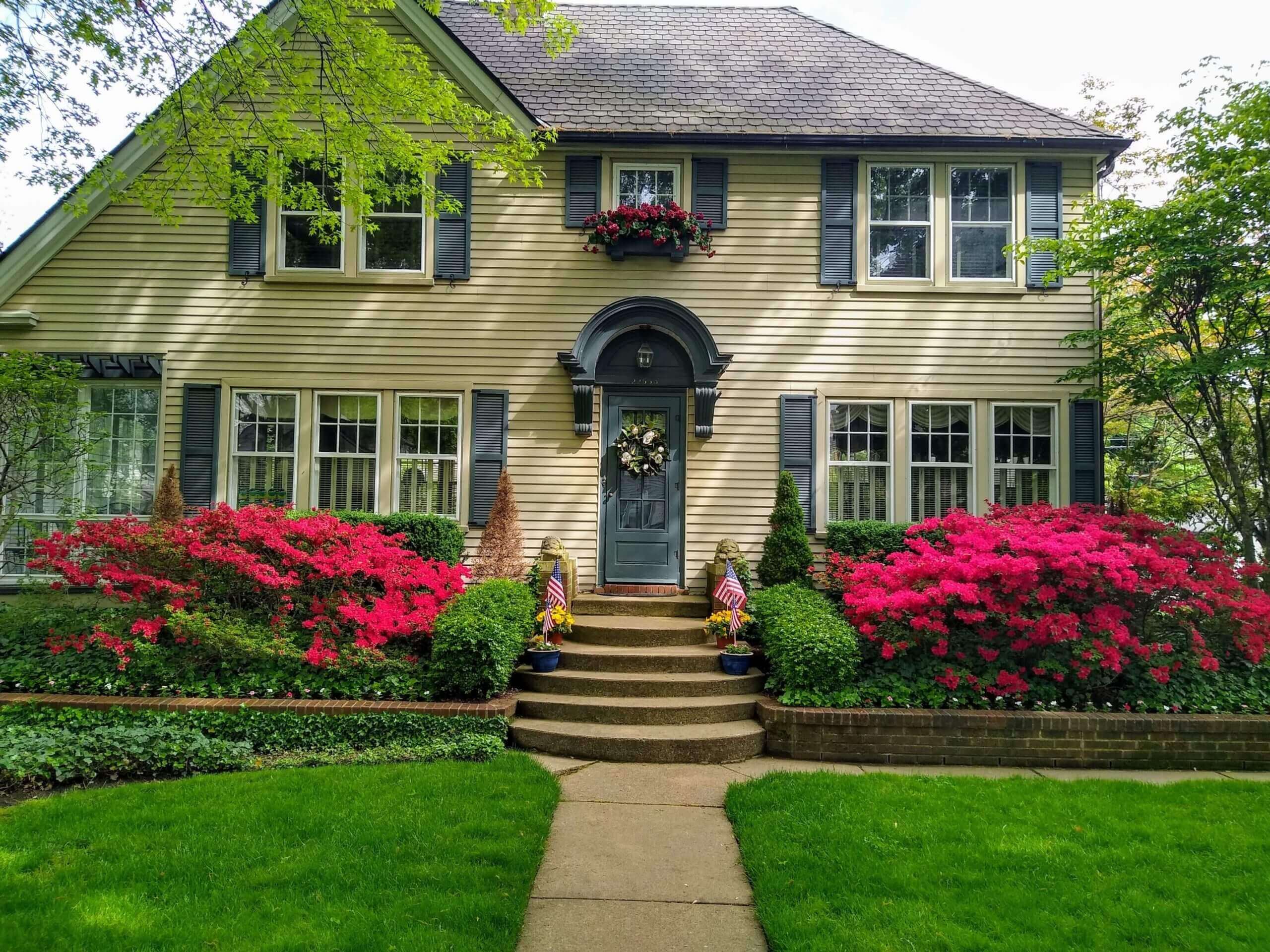 Two story house with yellow siding and dark cyan trim