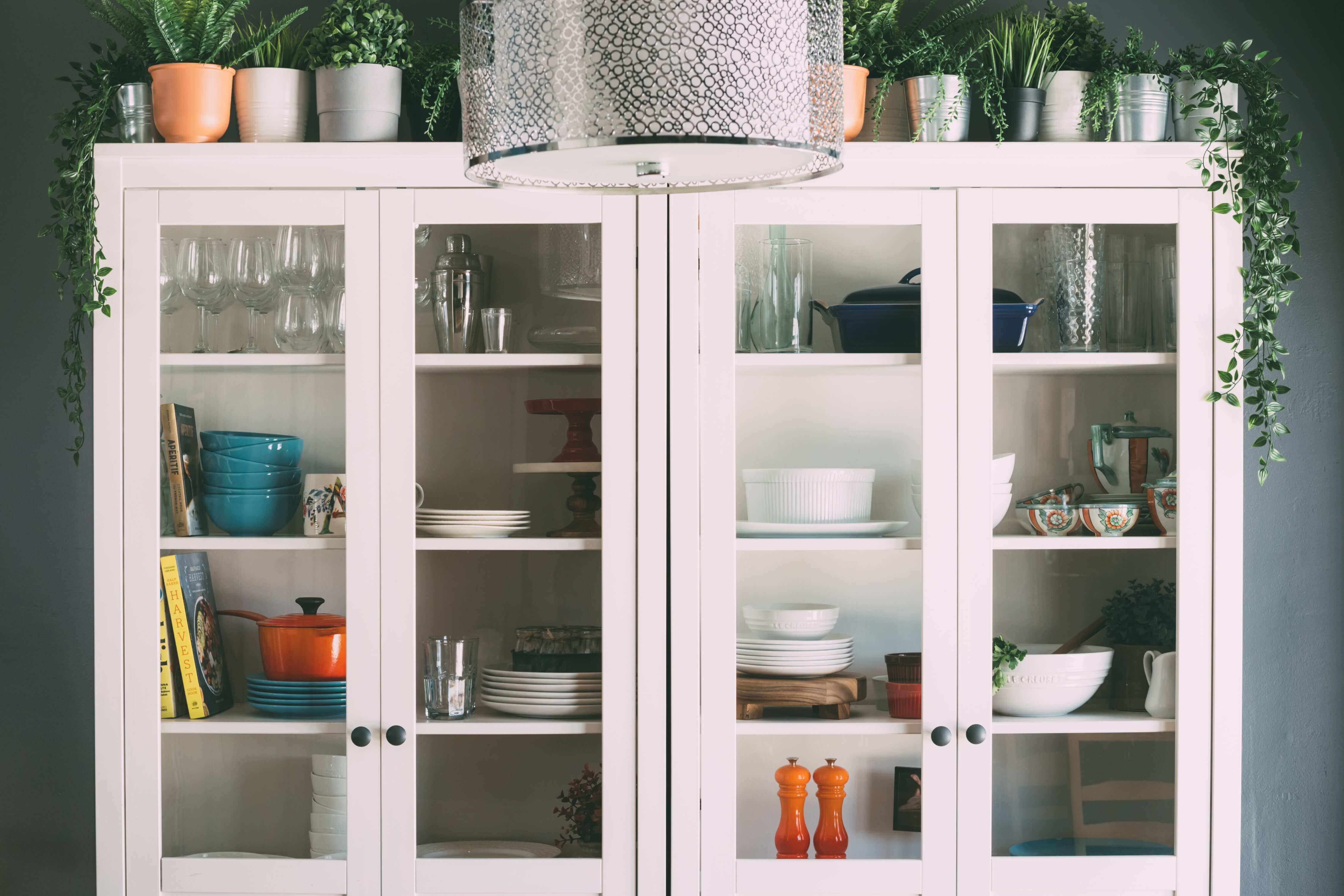 A set of kitchen cabinets with glass panels to see everything inside.