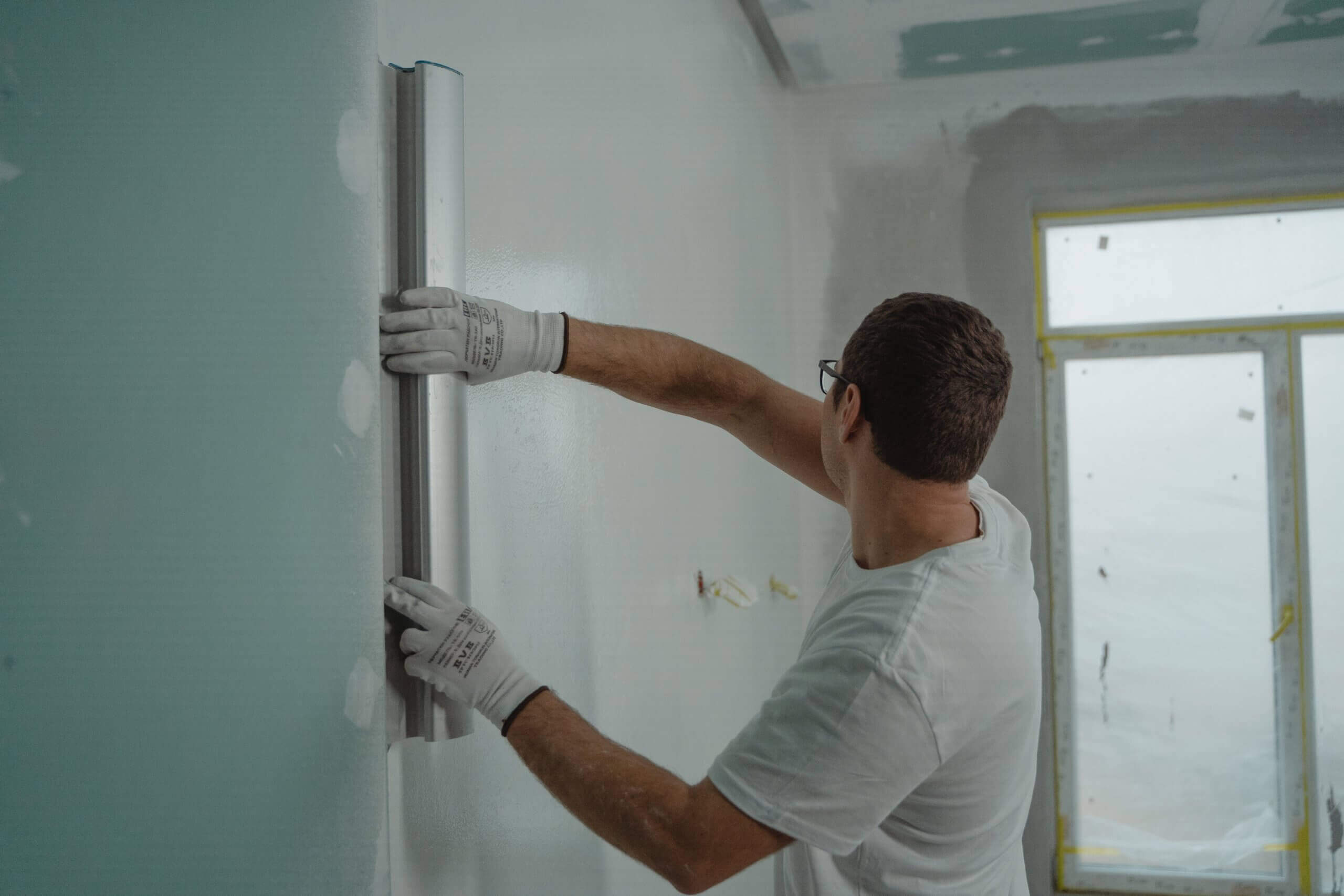 A man is painting the walls during a home renovation.