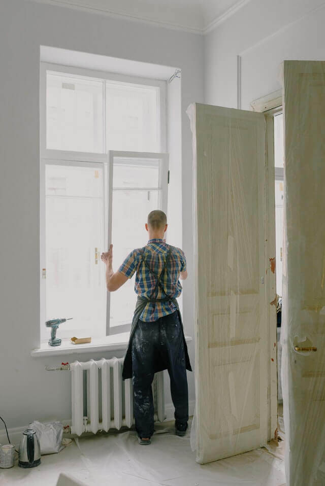 a man reinstalls windows in a home renovation project