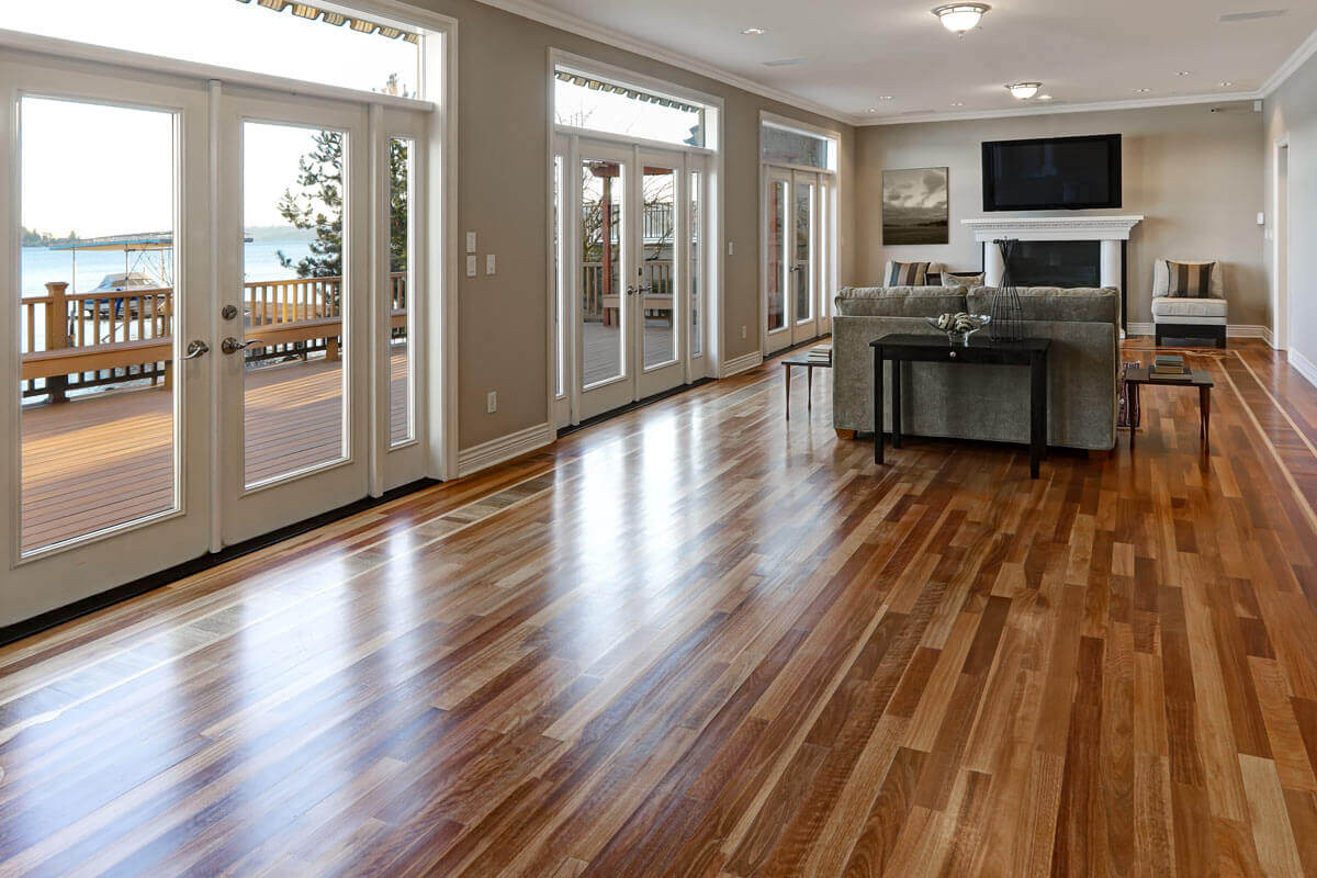 Home remodel with Large living room with long polished wood floor and large span of windows and glass doors leading to an outside deck